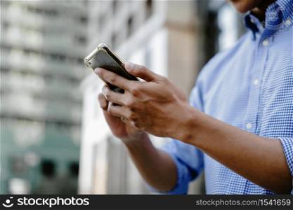 a Businessman Using Mobile Phone in the City. Cropped image, selective focus on Smartphone