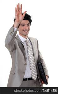 A businessman waving to someone.