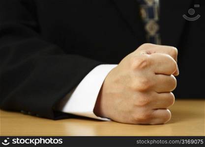 A businessman with his firm fist on a table