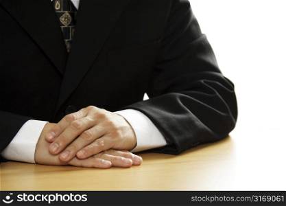 A businessman with his hands on a desk