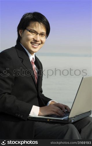 A businessman working on his laptop at the beach