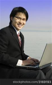 A businessman working on his laptop at the beach