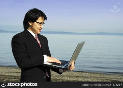 A businessman working on his laptop on the beach