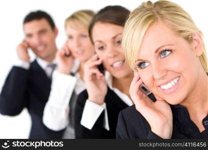 A businesswoman and her three colleagues out of focus behind her all talking on cell phones