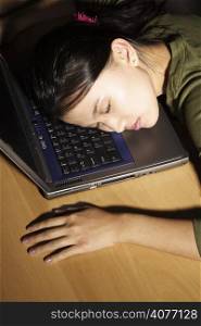A businesswoman falling asleep at work on her laptop