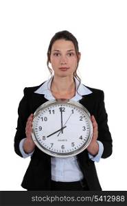 A businesswoman holding a clock.