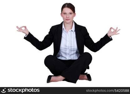 A businesswoman in a lotus position.