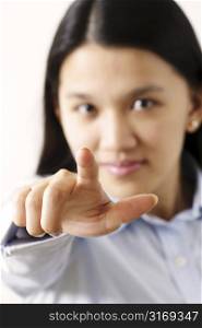 A businesswoman pointing (focus on index finger, shallow depth of field)