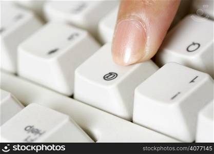 A businesswoman pressing a key on a keyboard