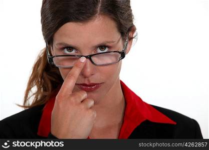 A businesswoman repositioning her glasses.