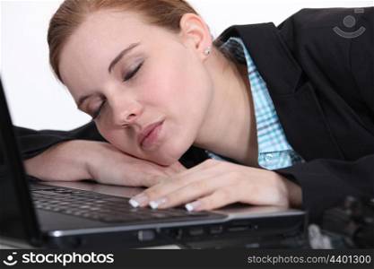 A businesswoman sleeping on her laptop.