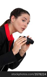 A businesswoman spying with binoculars.