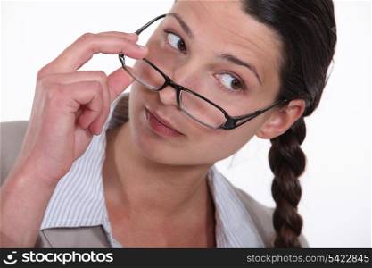 A businesswoman taking her glasses off.