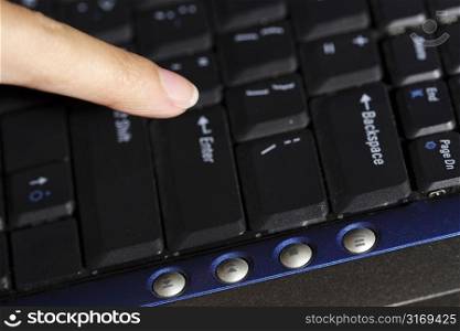 A businesswoman with her finger pointing at the enter key