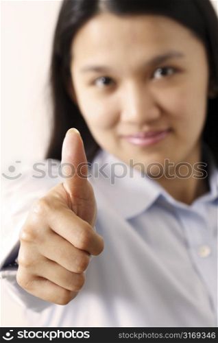 A businesswoman with her thumbs up (focus on thumb, shallow depth of field)
