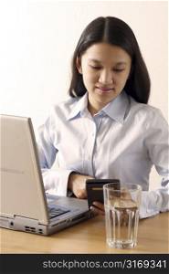 A businesswoman with laptop and calculator