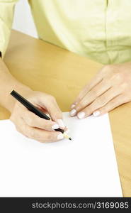 A businesswoman writing on a piece of blank paper