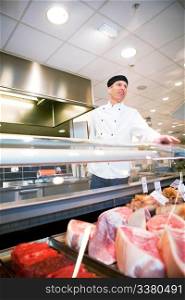 A butcher helping a customer at a fresh meat counter or deli