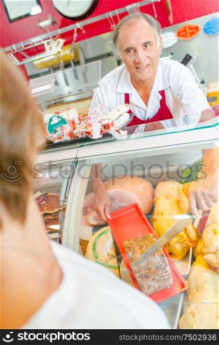 a butcher is serving a client