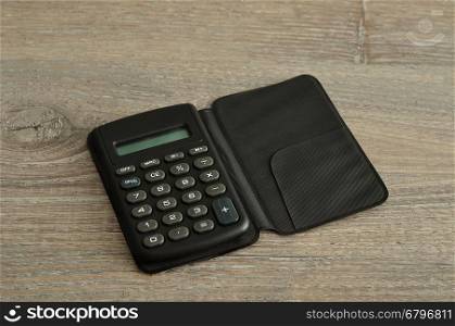 A calculator displayed on a wooden background
