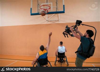a cameraman with professional equipment records a match of the national team in a wheelchair playing a match in the arena. High quality photo. Selective focus . a cameraman with professional equipment records a match of the national team in a wheelchair playing a match in the arena