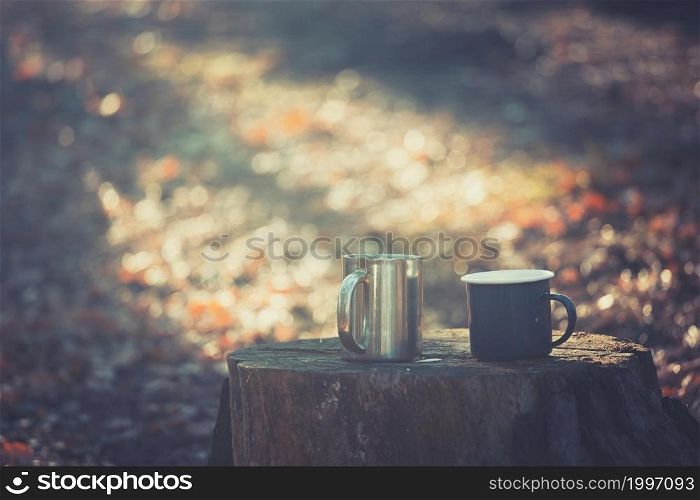 a camping aesthetics. cups with tea on a stump in the dawn light
