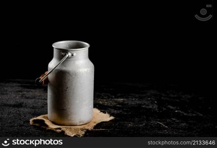 A can of milk on a napkin. On a black background. High quality photo. A can of milk on a napkin.