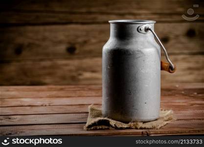 A can of village milk. On a wooden background. High quality photo. A can of village milk.