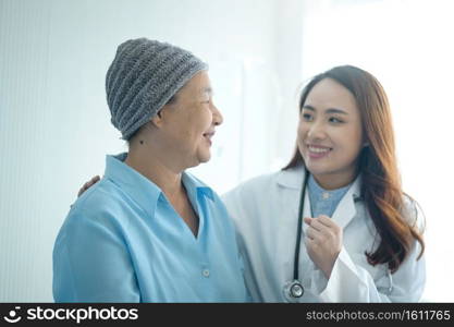 A cancer patient woman wearing head scarf after chemotherapy consulting and visiting doctor in hospital.. Cancer patient woman wearing head scarf after chemotherapy consulting and visiting doctor in hospital.