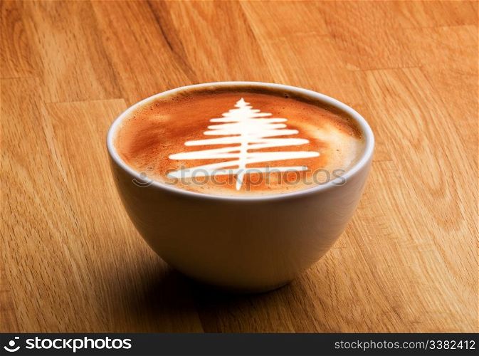 A cappuccino with a christmas tree in latte art