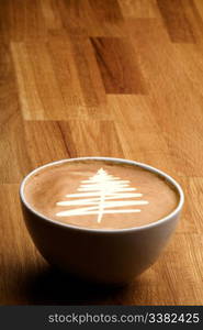 A cappuccino with a christmas tree in latte art