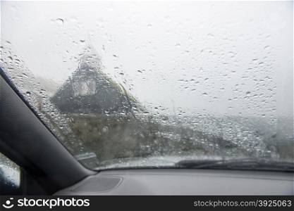 A car window in heavy rain. The front window of a car in heavy rain on a rainy day
