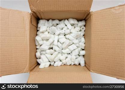 A cardboard box with packing foam pellets top view