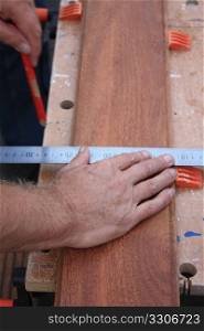 A Carpenter Getting Ready For Work, measuring wood