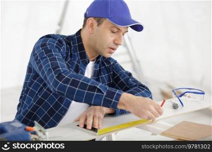a carpenter is measuring a board