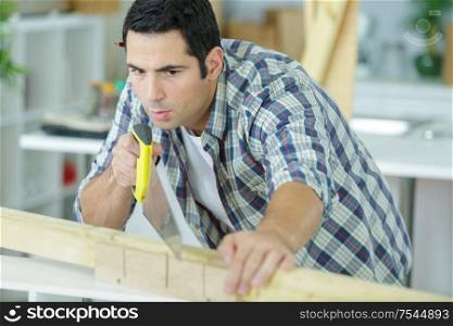 a carpenter is sawing wood