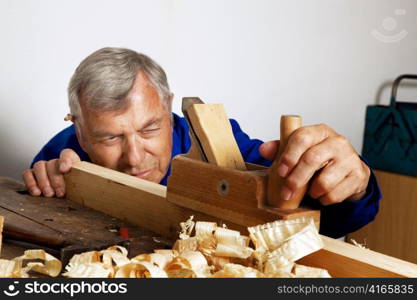 a carpenter with a planer and wood shavings in the workshop.