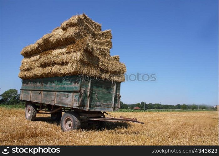 a cart with straw standing on a box. after the harvest