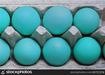 A carton with blue easter eggs