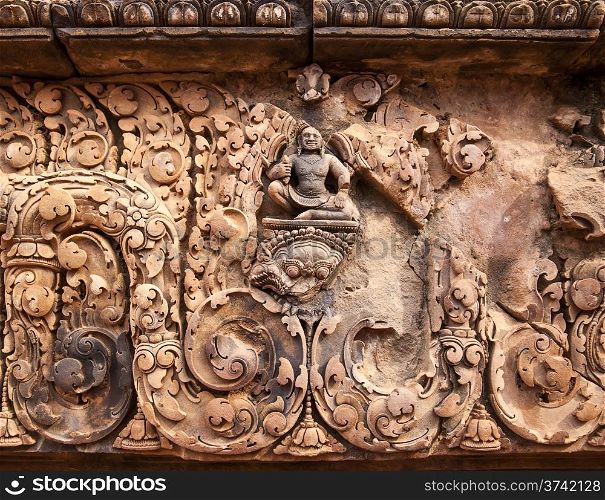A carving of Buddha amidst other details above an entrance to one of the smaller buildings at the Banteay Srei temple near Angkor Wat.&#xA;