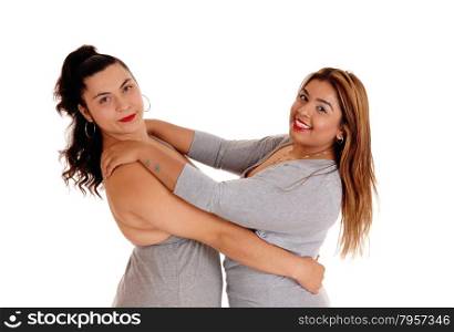 A Caucasian and East Indian woman holding each other, both in gray dressesisolated for white background.