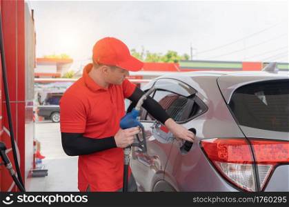 A Caucasian man, people, worker filling up fuel by using petrol pump at gasoline petrol station, refuel petroleum oil and energy vehicle business service in transportation concept.
