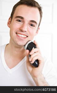 A caucasian man shaving in the bathroom