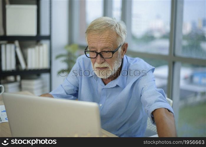 A caucasian senior Businessman working in modern office. Caucasian senior Businessman working in modern office