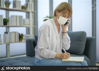 A caucasian senior Businesswoman with mask is working in modern office. Caucasian senior Businesswoman with mask is working in modern office
