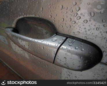 a cdoor handle of a rain-soaked car