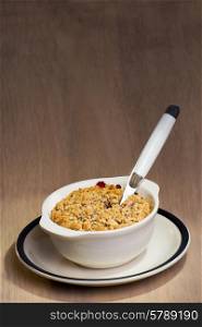 A ceramic dish with freshly baked mixed berry crumble, and a spoon stuck in to the berry crumble.