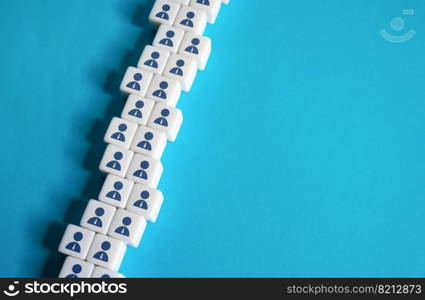 A chain of blocks of workers on a blue background. Place for text. Copyspace. Help wanted. Hiring new employees for vacancies. Human resources and work force. Staffing and recruiting candidates