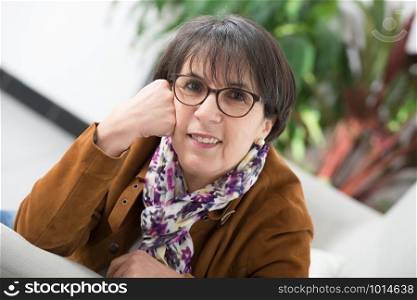 a charming mature woman with brown jacket and glasses