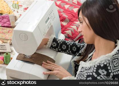 a cheerful young seamstress with her sewing machine